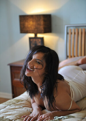 Lovely black-haired lassie sensually poses while discarding underwear bodysuit