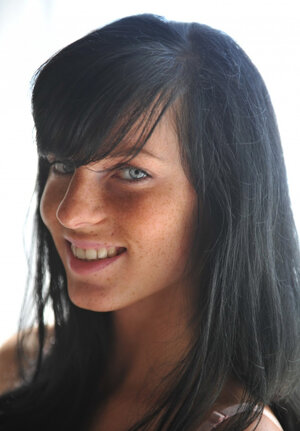 Charming brunette girl drops off shirt to erotically pose in the bedroom