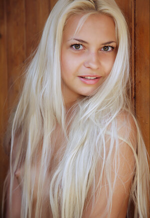 Nice-looking blonde with sexy tan lines exposes her assets in front of the door