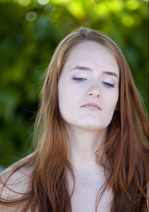 Comely redhead Denisa Heaven prefers to relax entirely undressed under the sun