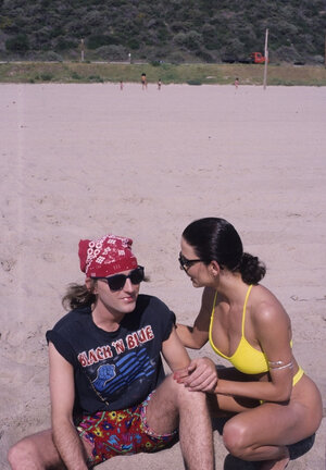 Man in red bandana plays guitar pretty well but girls are interested in threesome