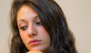 Naked brunette teasing the camera with her larger backside