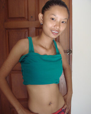 Slim Oriental kitten is going to show naked body in a doorway