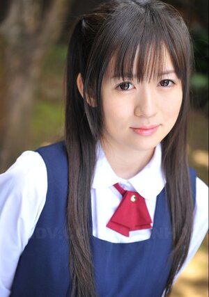 Innocent Japanese schoolgirl with attractive eyes walks seductively under sun