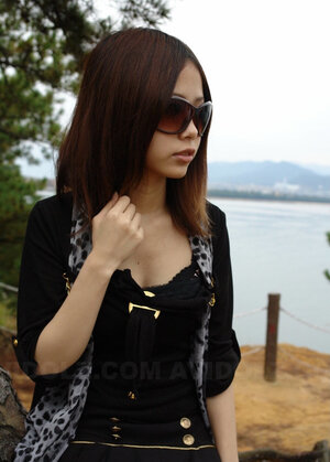 Far eastern chick with sunglasses on looks so seriously because she is shy being naked