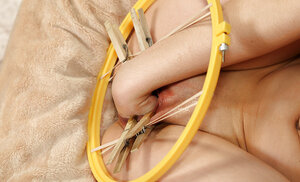 Chick with skinny body plays with a round pussy-spreader and fists it