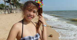 Thai broads rest on a beach and pose in tight bikini flashing innie navels