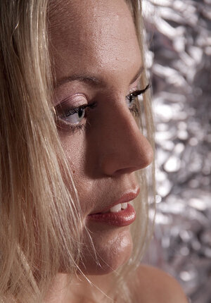 Adorable blonde seductively undresses in strange room covered with foil