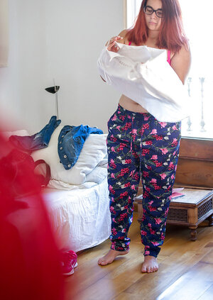 Plus-sized redhead on pink underwear to get fully dressed next to the window