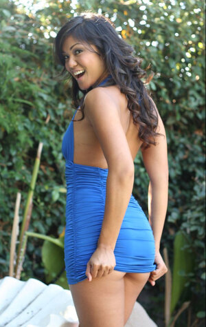 Asiatic diva poses outdoors dressed in blue dress that accentuates her curves