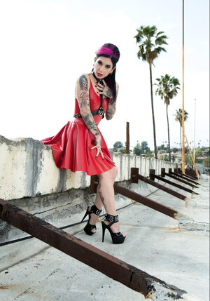 Floozy with pink locks in a red vinyl dress goes outdoors for a naked photoshoot