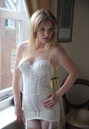 Cute blonde discards vintage dress till she is left in corset and stockings